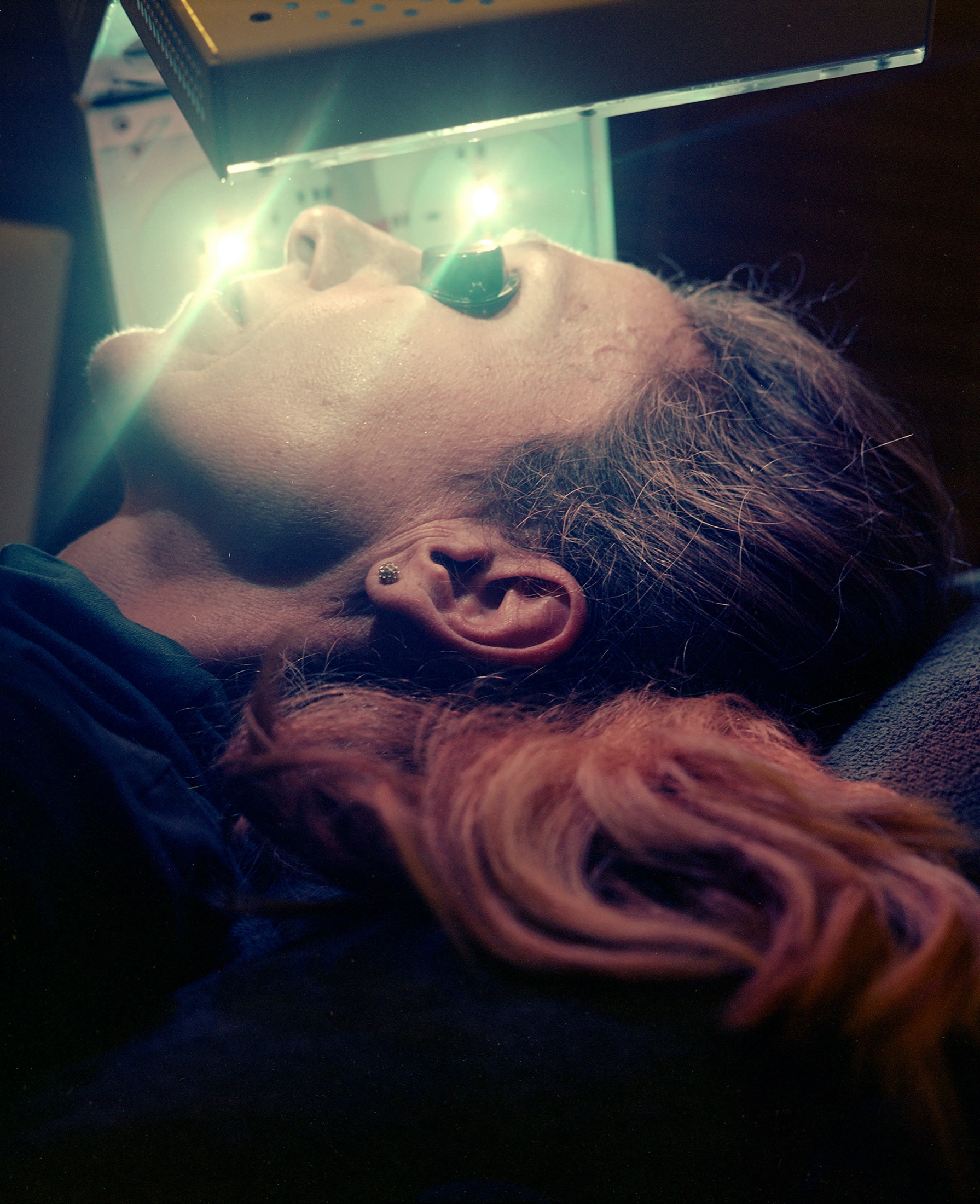 Femme allongée, la tête sous une lampe de luminothérapie